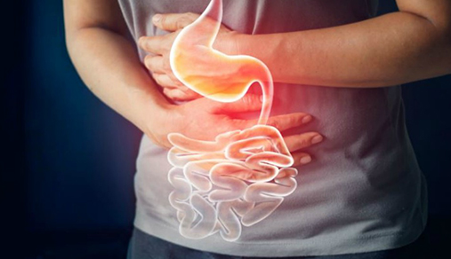 Close-up of hands grasping stomach area with illuminated stomach and intestines