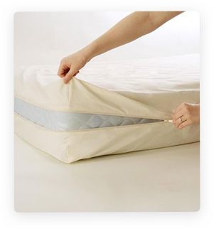 Hands zipping up mattress cover