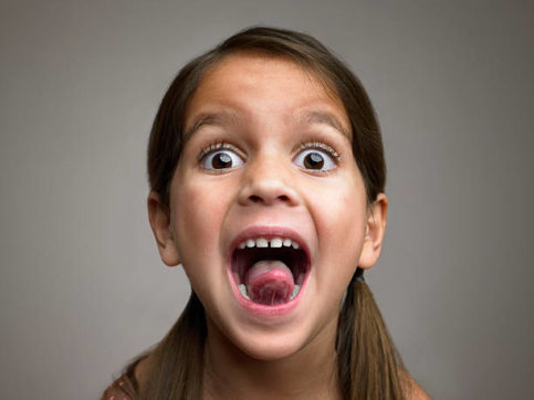 Wide-eyed girl sticking out her tongue