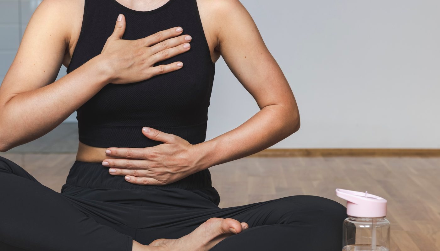 Woman doing breathing exercise sitting in lotus position